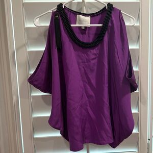 purple silk blouse with black cord neck and tassel